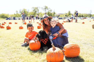 Aubrey TX fall decor with family sitting in a pumpkin patch together
