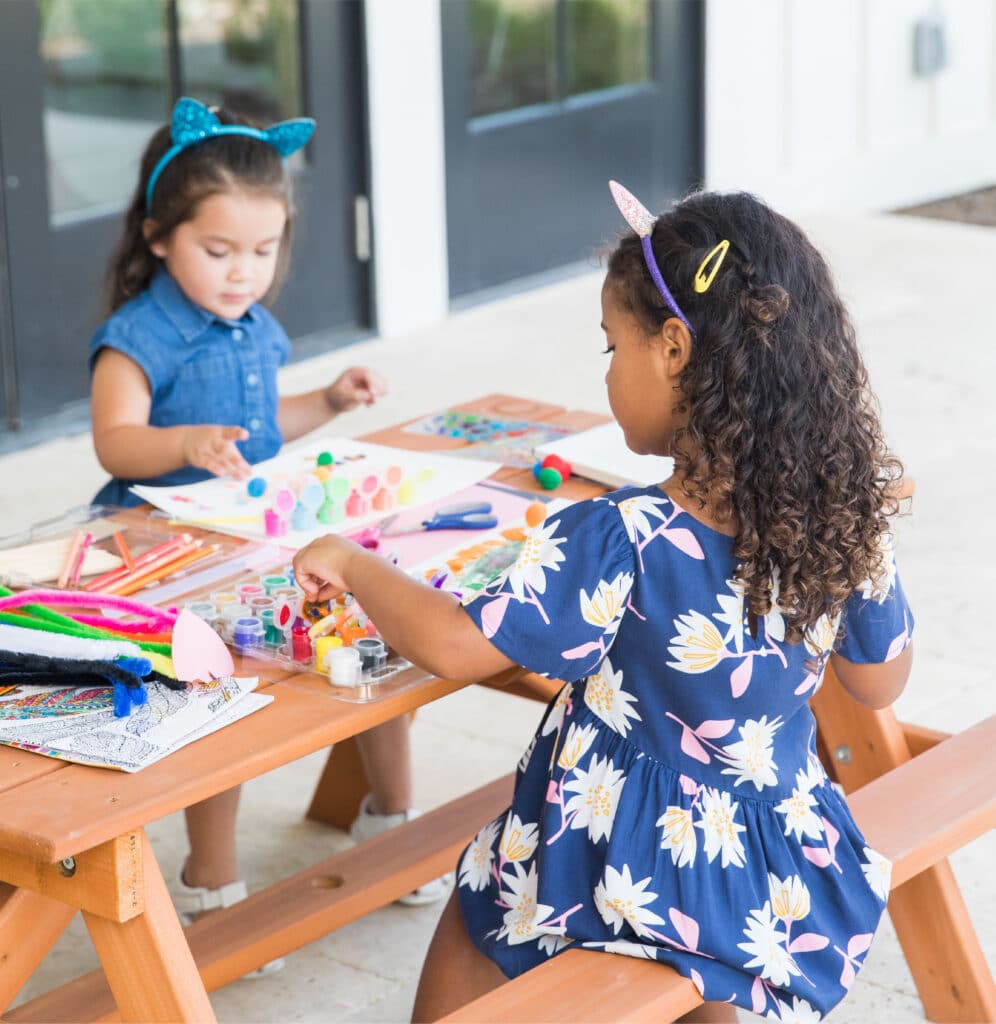two little girls painting on the back porch of The Carriage House